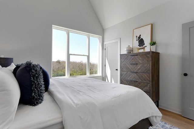 bedroom with wood-type flooring and lofted ceiling