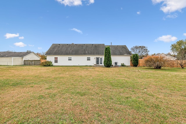 rear view of property featuring a lawn