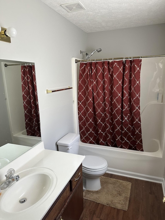 full bathroom featuring wood-type flooring, vanity, toilet, shower / bathtub combination with curtain, and a textured ceiling