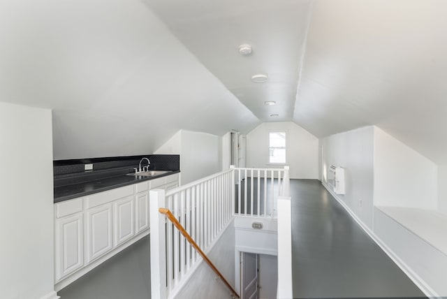 interior space with lofted ceiling, sink, and concrete flooring