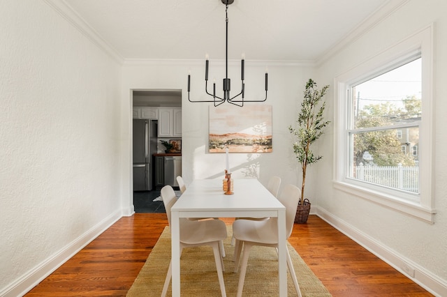 dining space with crown molding, hardwood / wood-style flooring, and a chandelier