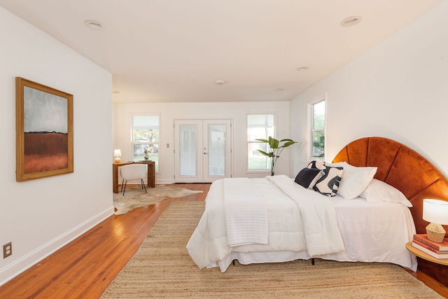 bedroom featuring multiple windows, french doors, and wood-type flooring