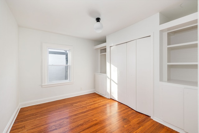 unfurnished bedroom featuring wood-type flooring and a closet