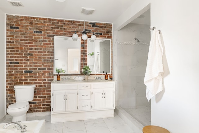 bathroom featuring vanity, a tile shower, toilet, and brick wall