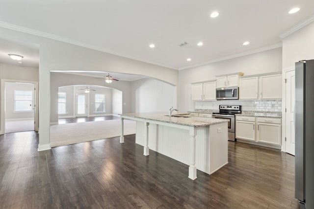 kitchen featuring white cabinets, appliances with stainless steel finishes, a kitchen island with sink, dark wood-type flooring, and sink