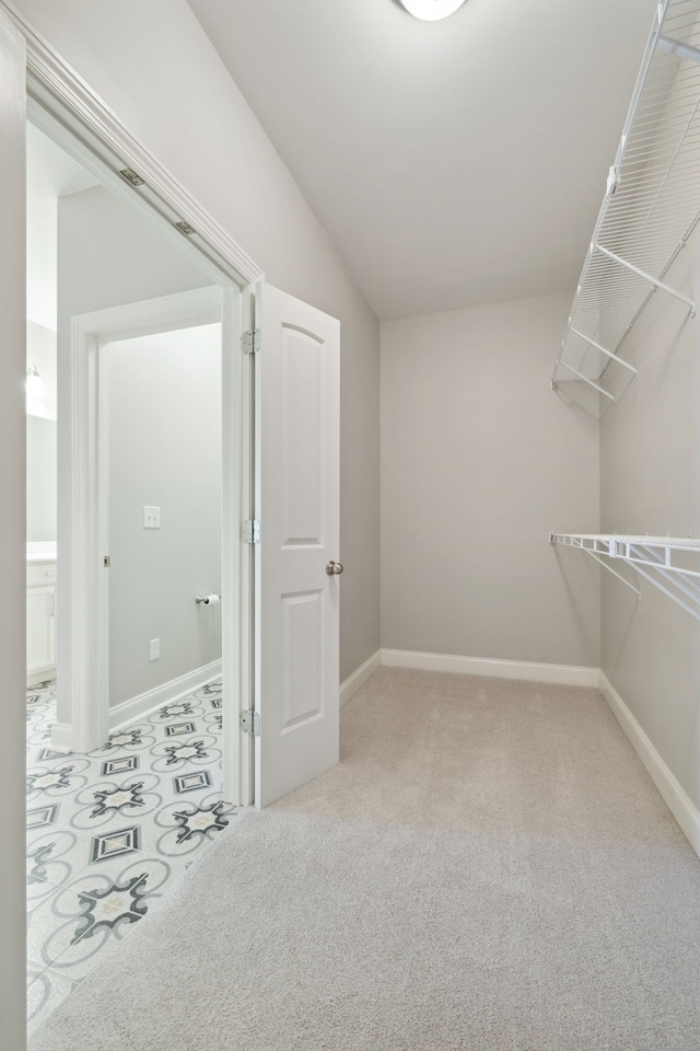 walk in closet featuring light colored carpet