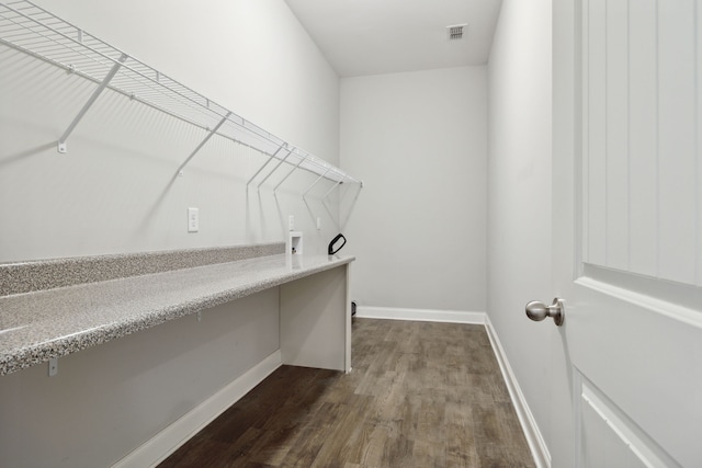 spacious closet with dark hardwood / wood-style flooring