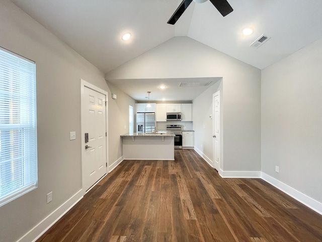 kitchen featuring kitchen peninsula, stainless steel appliances, lofted ceiling, white cabinets, and dark hardwood / wood-style floors