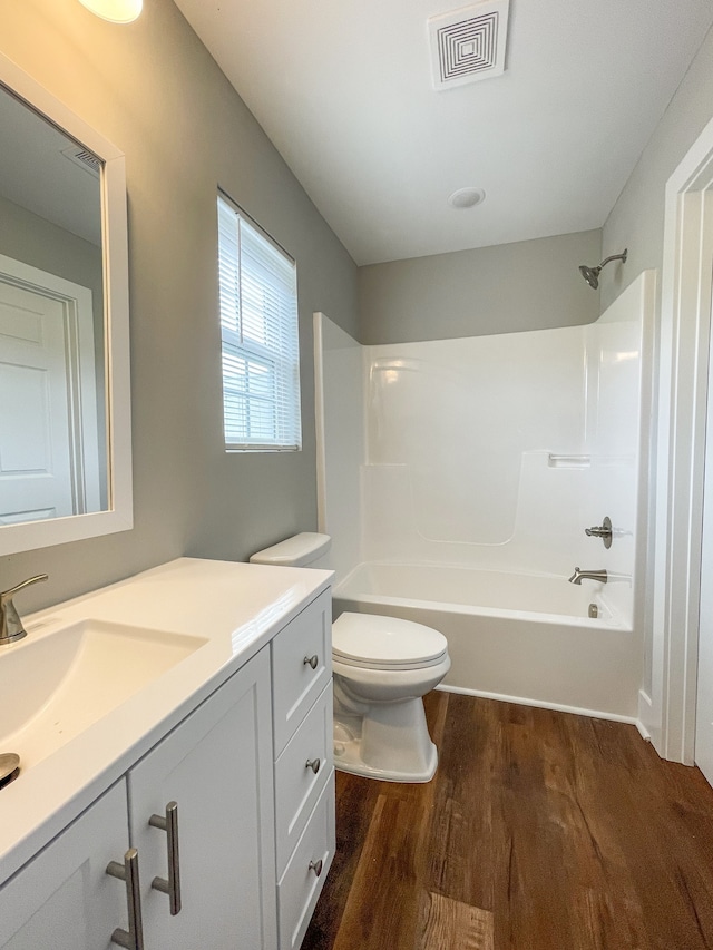 full bathroom with toilet, bathtub / shower combination, hardwood / wood-style floors, and vanity