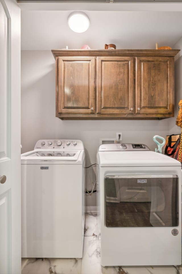 washroom with washing machine and clothes dryer and cabinets