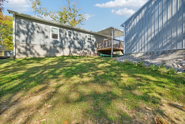 rear view of property featuring a wooden deck and a yard