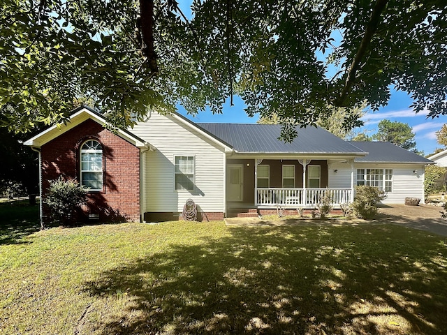 ranch-style home with brick siding, a porch, a front yard, crawl space, and metal roof