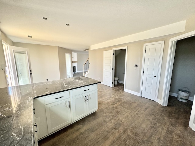 kitchen featuring white cabinetry, dark wood-type flooring, and dark stone countertops