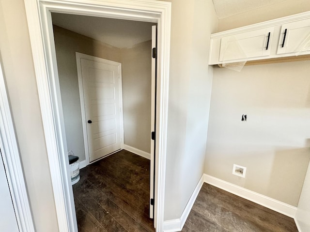 laundry room featuring dark wood finished floors and baseboards