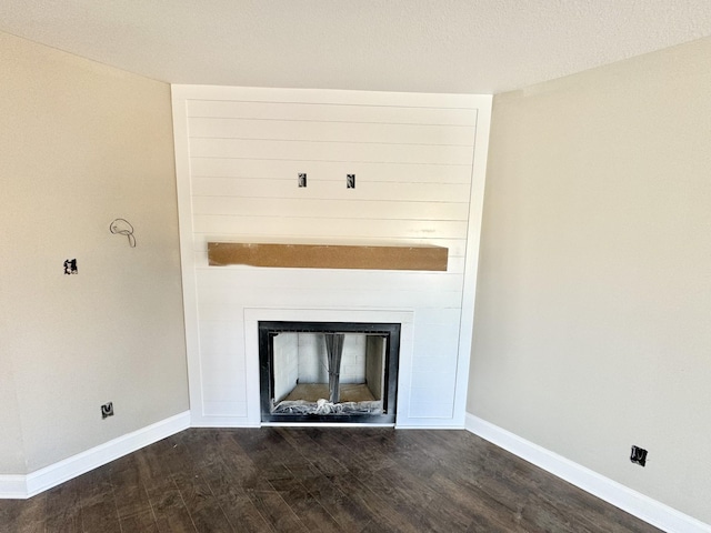 room details featuring a fireplace, baseboards, and wood finished floors