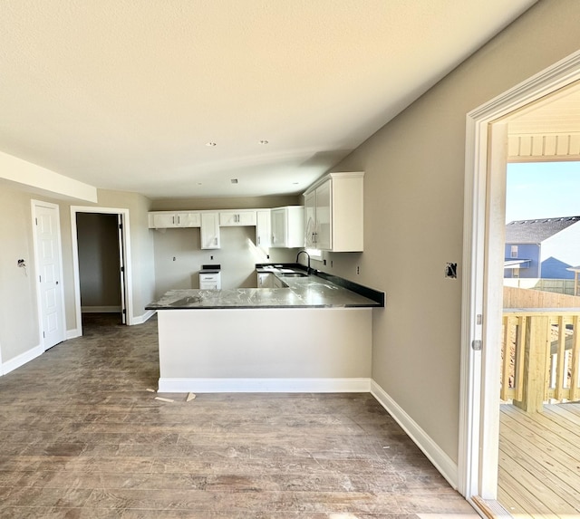 kitchen featuring white cabinetry, sink, hardwood / wood-style flooring, and kitchen peninsula