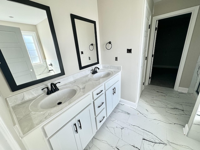 bathroom featuring double vanity, baseboards, marble finish floor, and a sink