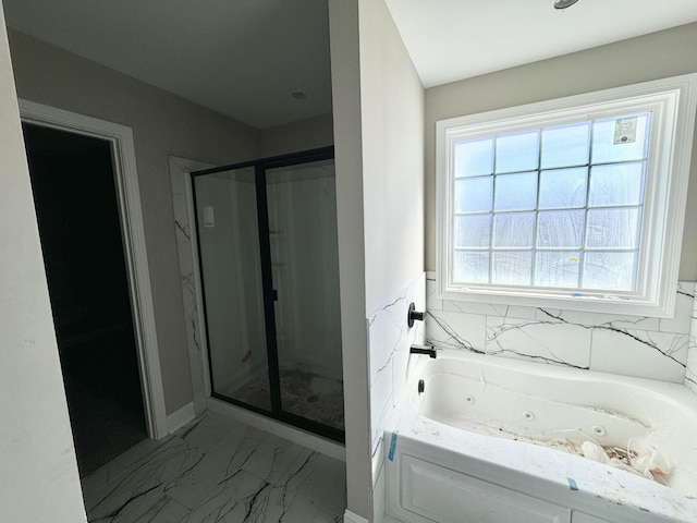 full bathroom featuring marble finish floor, a stall shower, and a jetted tub