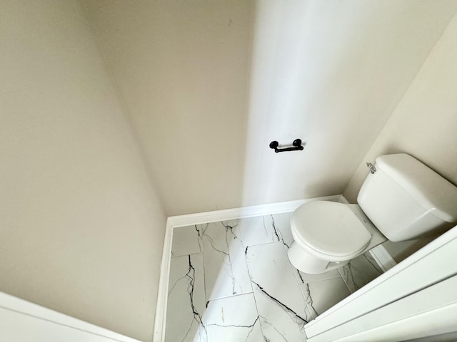 bathroom with toilet and marble finish floor