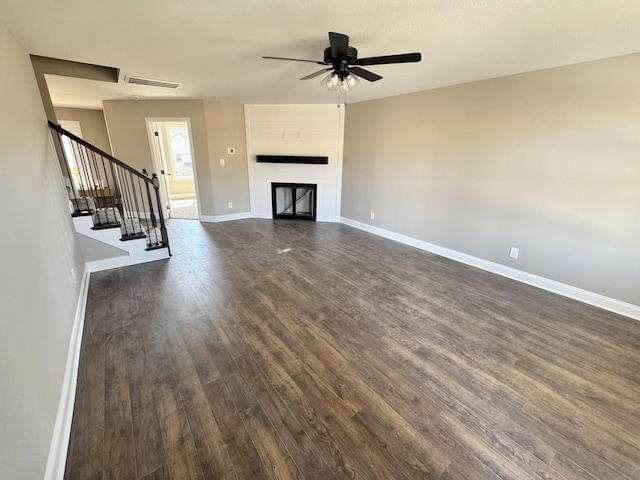 unfurnished living room with visible vents, dark wood-style floors, a fireplace, baseboards, and stairs