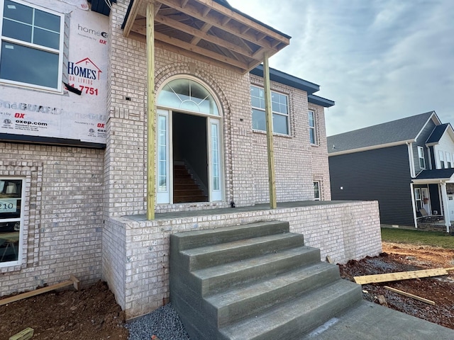 doorway to property featuring brick siding