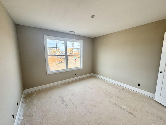 spare room with baseboards and visible vents