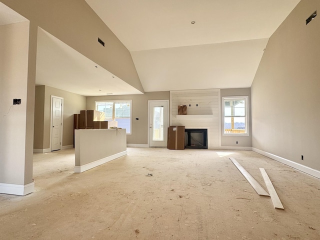 unfurnished living room featuring baseboards, a large fireplace, and lofted ceiling