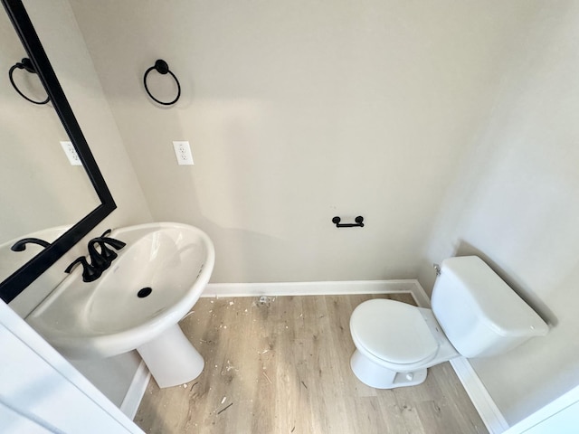 bathroom with hardwood / wood-style flooring and toilet