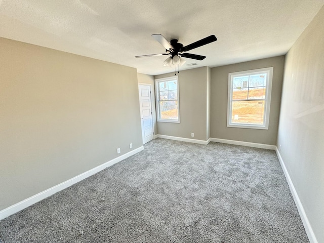 carpeted empty room with ceiling fan and a textured ceiling