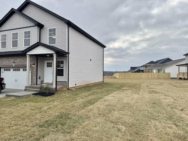 view of front of home featuring a garage, a front lawn, and fence