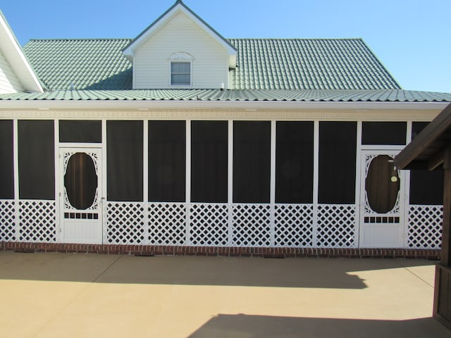 view of property exterior with a sunroom