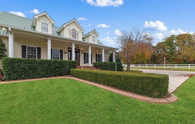 cape cod home with covered porch and a front yard