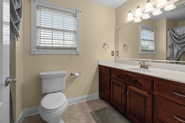 bathroom with toilet, vanity, and tile patterned flooring