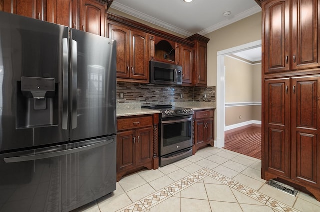 kitchen with tasteful backsplash, appliances with stainless steel finishes, light tile patterned flooring, crown molding, and light stone counters