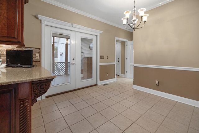 kitchen featuring french doors, light stone counters, pendant lighting, crown molding, and a notable chandelier