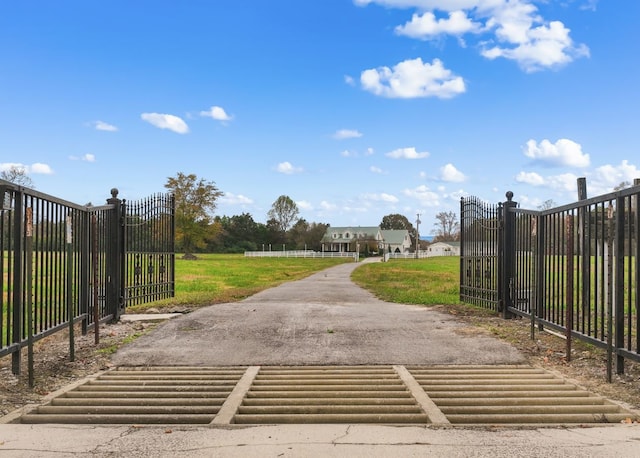 view of gate with a lawn