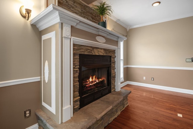 room details with hardwood / wood-style floors, a stone fireplace, and crown molding