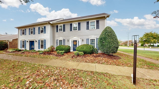 colonial home with a front lawn