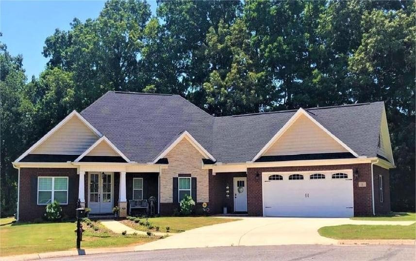 craftsman-style home featuring a porch, a garage, and a front lawn