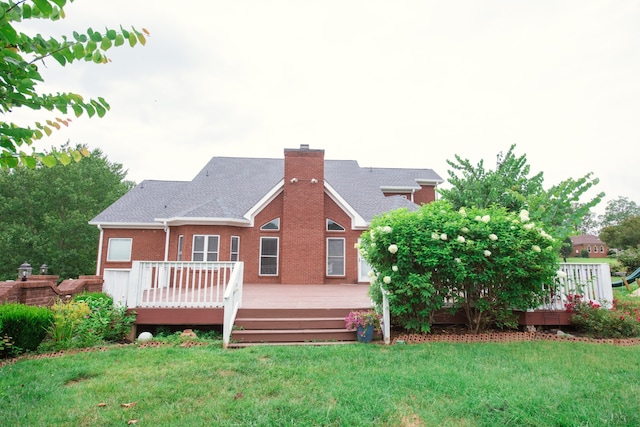 rear view of house featuring a deck and a lawn