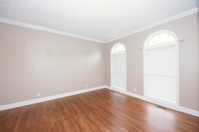 spare room featuring ornamental molding, a textured ceiling, and wood-type flooring