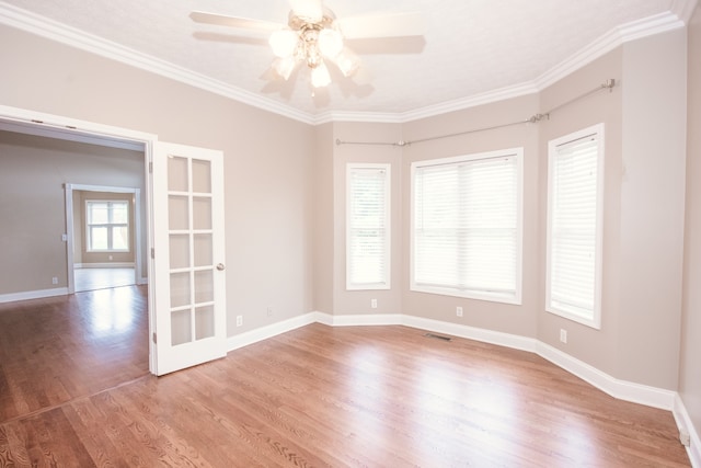 empty room featuring ornamental molding, french doors, light hardwood / wood-style flooring, and ceiling fan