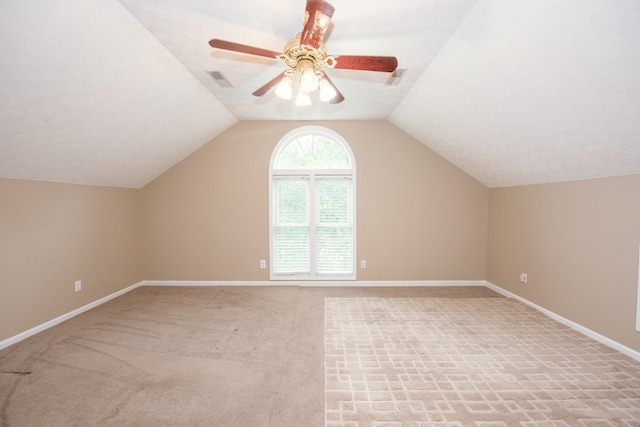 additional living space with ceiling fan, vaulted ceiling, and light colored carpet