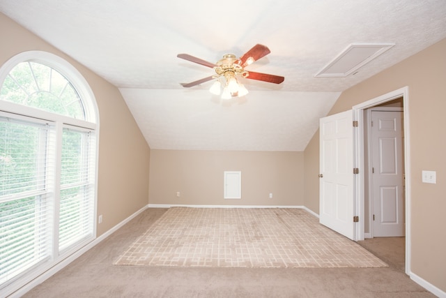 additional living space with light carpet, a textured ceiling, ceiling fan, and vaulted ceiling