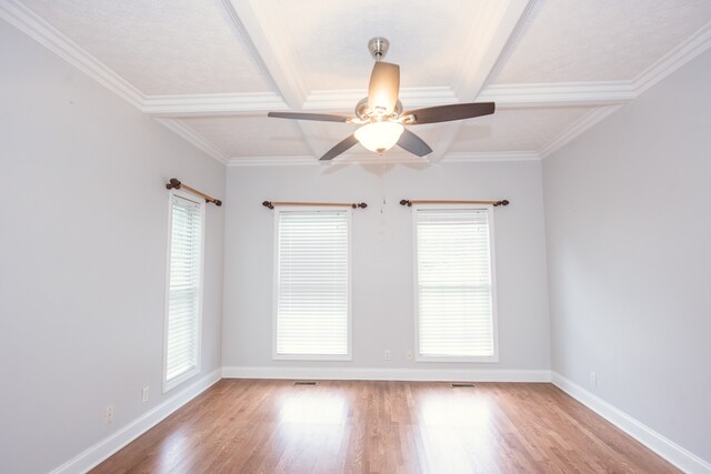 spare room featuring beamed ceiling, crown molding, light hardwood / wood-style flooring, and ceiling fan