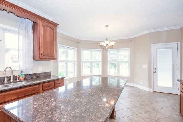 kitchen featuring a chandelier, a center island, sink, crown molding, and decorative light fixtures