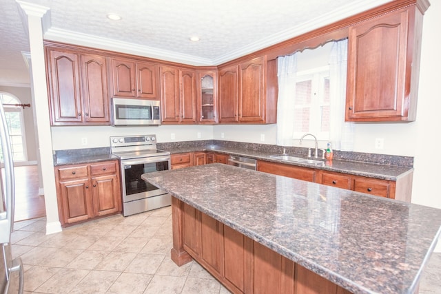 kitchen with a textured ceiling, light tile patterned flooring, sink, crown molding, and stainless steel appliances