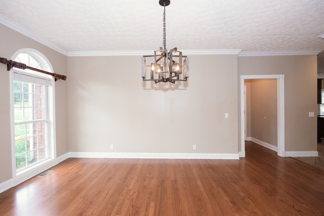 empty room featuring crown molding, a notable chandelier, and hardwood / wood-style flooring