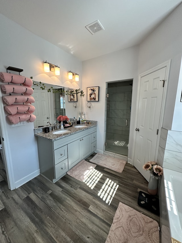 bathroom featuring vanity, wood-type flooring, and separate shower and tub