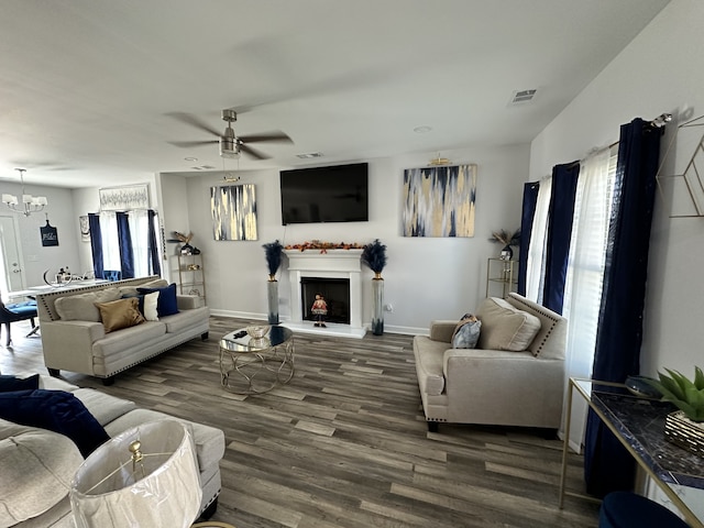 living room featuring dark hardwood / wood-style flooring and ceiling fan with notable chandelier